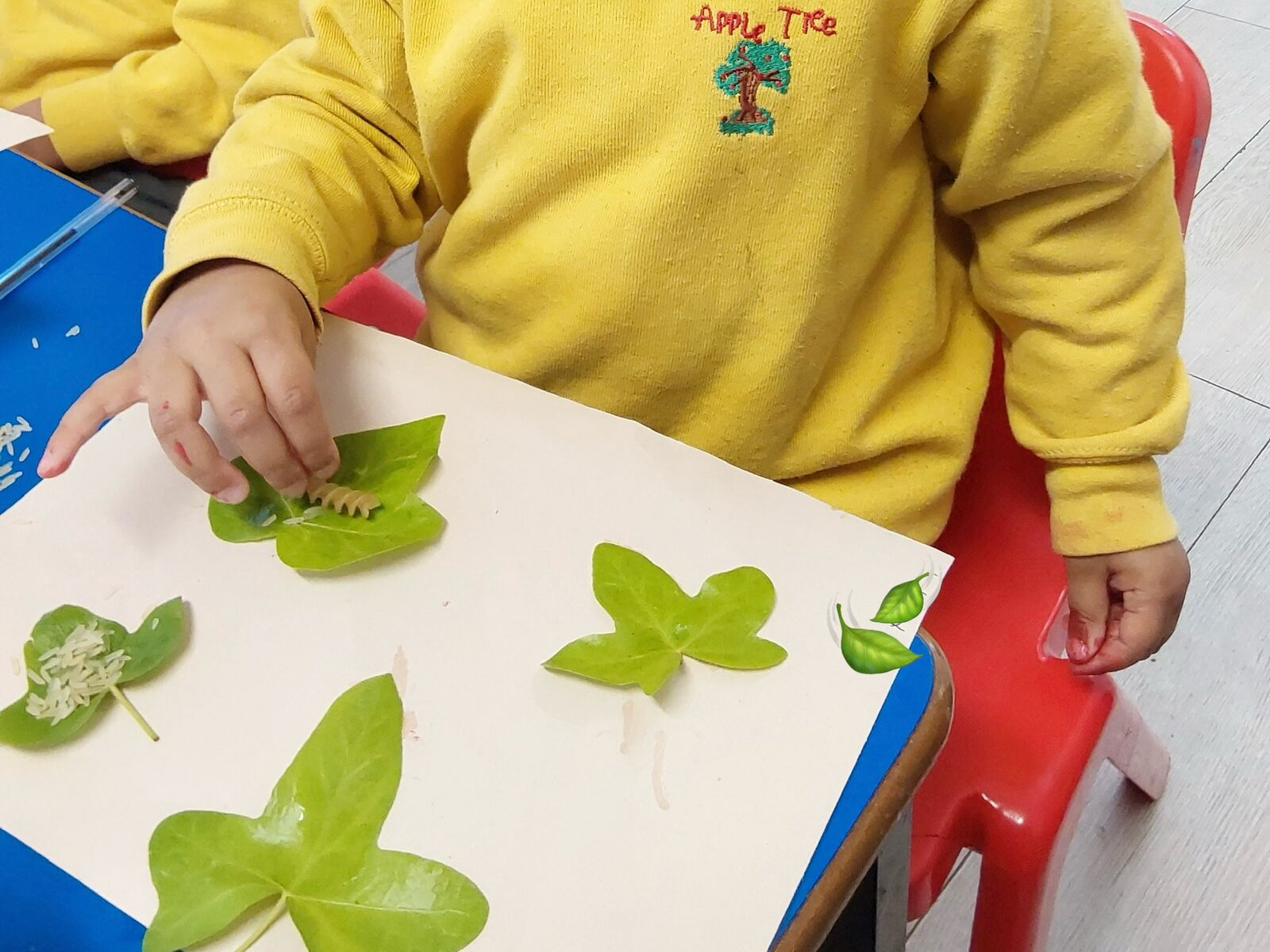 Toddlers exploring sensory outdoor garden activities at Apple Tree Montessori Nursery