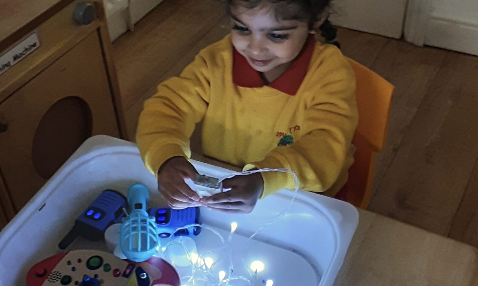 Young child practising Montessori practical life skills with wooden materials at Apple Tree Nursery